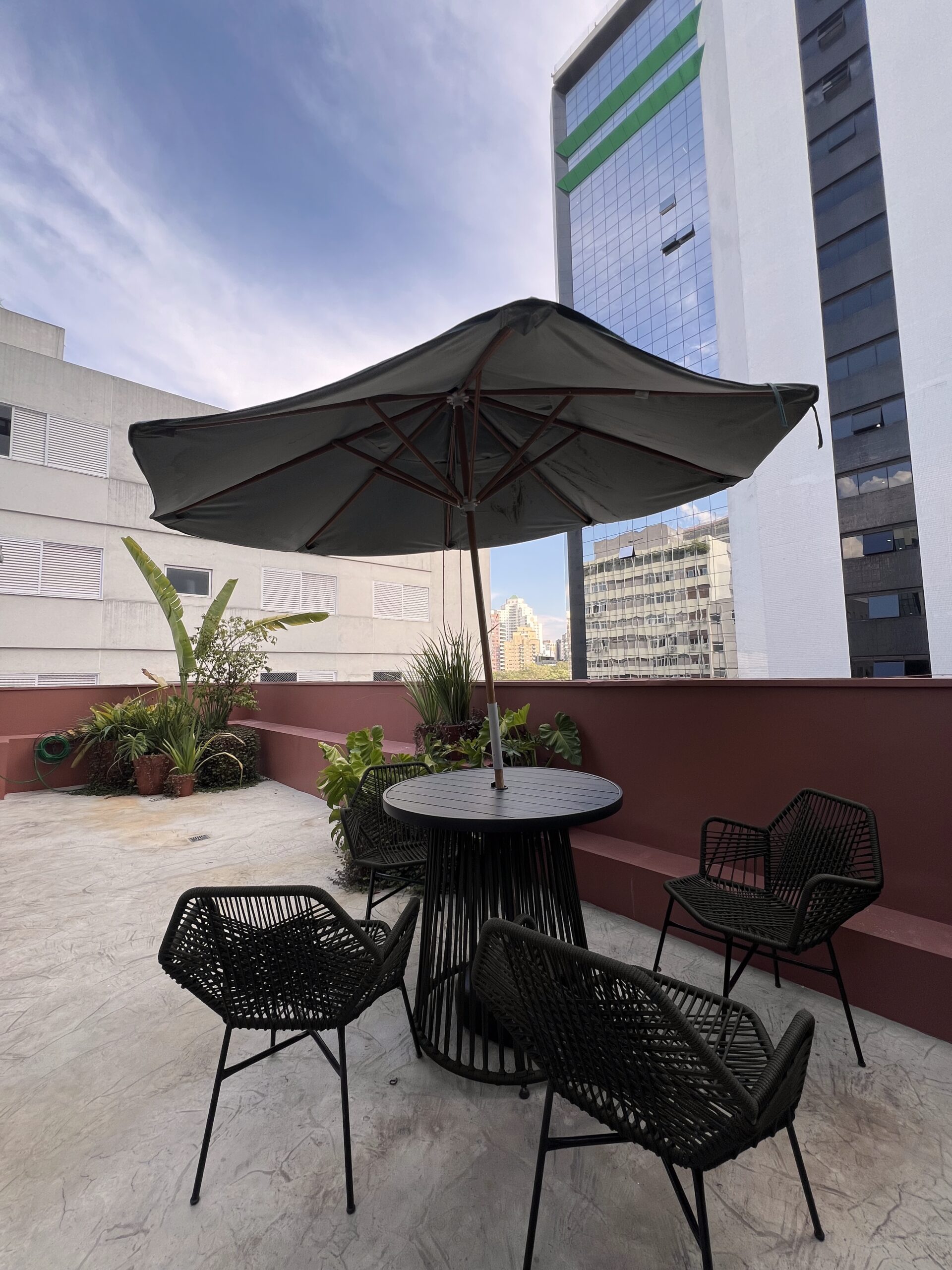 Terraço externo da Meraki com mesa e guarda-sol