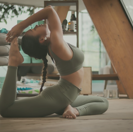 Aluna realizando alongamento em aula de Pilates no solo